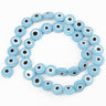 Light blue flat round beads with white eye rings and black centers, arranged in a loop