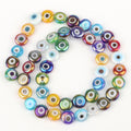 Multicolored flat round evil eye beads with rainbow reflections, arranged in a loop