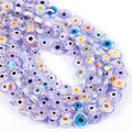Pale purple flat round evil eye bead strands with iridescent reflections on a white background