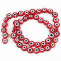 Red flat round beads with white and pale blue eye rings surrounding black centers