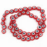 Red flat round beads with white and pale blue eye rings surrounding black centers