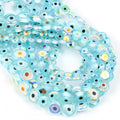 Overlapping strands of pale turquoise flat round evil eye beads with rainbow reflections