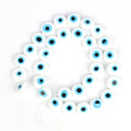 White flat round beads with light blue eye rings and black centers, arranged in a loop