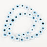 White flat round beads with light blue eye rings and black centers, arranged in a loop