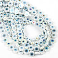 Overlapping strands of white flat round evil eye beads with pale blue details and iridescent reflections
