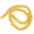 Yellow flat round beads with white and pale blue eye rings surrounding black centers
