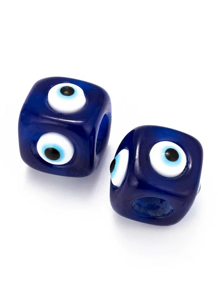 Two deep blue cube evil eye beads showing rounded corners, eye motifs and bead openings