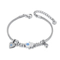 Silver tone snake chain bracelet with a blue-eyed Hamsa hand, heart charm and clear round drop