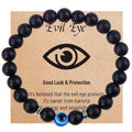 Matte black round bead bracelet with a blue eye bead and silver tone spacers on a printed card