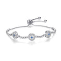 Silver tone bracelet with three round blue-centered eye medallions, clear accents and a round slider