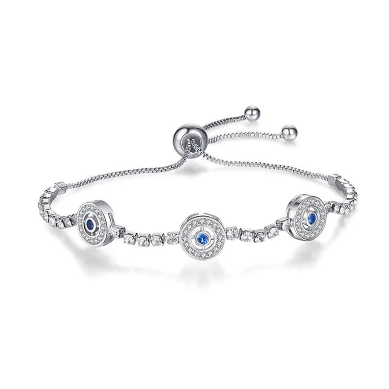 Silver tone bracelet with three round blue-centered eye medallions, clear accents and a round slider