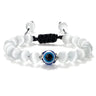 Translucent white round beads surrounding a blue eye, with silver tone accents and knotted black cord
