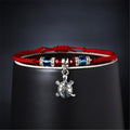 Red cord bracelet with blue eye beads, dark red faceted beads and a dangling silver tone turtle charm