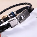 Close-up of the hook-and-slot clasp joining the black bracelet strands.