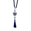 Heart-shaped blue evil eye ornament with a black bead loop, silver tone frame and blue tassel