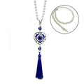 Heart-shaped blue evil eye ornament with white beads and a blue tassel; inset shows the bead loop