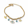 Gold tone chain bracelet with a central open eye charm, smaller eyelash charms, blue round accents and a clasp on a white background.