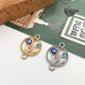 Gold tone and silver tone floral circle connectors with colorful eye motifs and loops at opposite ends.
