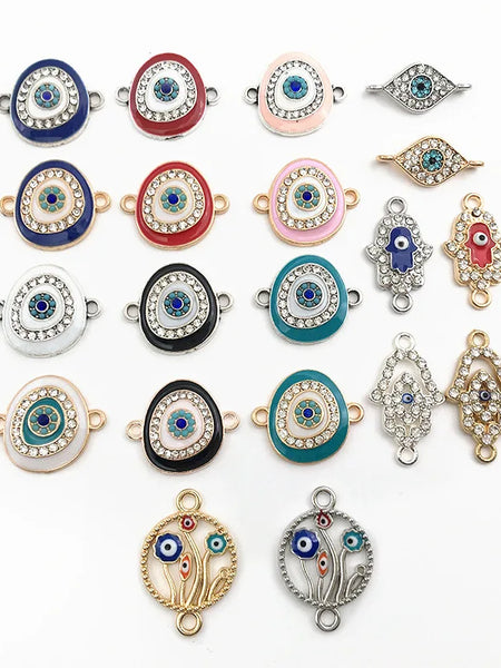 Oval eye, almond eye, Hamsa and floral circle connector charms arranged on a white background.