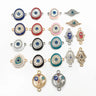 Oval eye, almond eye, Hamsa and floral circle connector charms arranged on a white background.