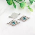 Silver tone almond eye connectors with turquoise centers and clear accents, showing fronts and a grooved back.
