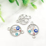 Silver tone floral circle connectors with multicolored eye motifs on curved stems, shown from the front and back.