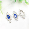 Silver tone Hamsa connectors with blue inner hands and central eyes, showing front and back views.