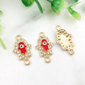 Gold tone Hamsa connectors with red inner hands and central eyes, shown from the front and back.