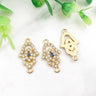Gold tone open Hamsa connectors with clear accents and central eyes, shown from the front and back.