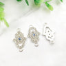 Silver tone open Hamsa connectors with clear accents and central eyes, shown from the front and back.