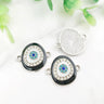 Black oval Evil Eye connectors with silver tone frames, showing decorated fronts and a grooved back.