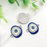 Blue oval Evil Eye connectors with silver tone frames, showing decorated fronts and a grooved back.