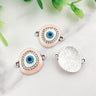 Pink oval Evil Eye connectors with silver tone frames, showing decorated fronts and a textured reverse.