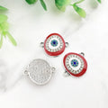 Red oval Evil Eye connectors with silver tone frames, showing two decorated fronts and one grooved back.