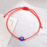 Blue evil eye bead on a red cord bracelet with a knotted back and gold tone bead tips