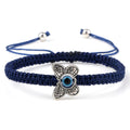 Blue knotted cord bracelet with a patterned silver tone butterfly and central blue eye