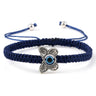 Blue knotted cord bracelet with a patterned silver tone butterfly and central blue eye