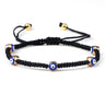 Black knotted cord bracelet with five spaced blue eyes in gold tone borders