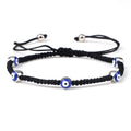 Black knotted cord bracelet with five spaced blue eyes in silver tone borders