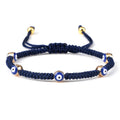Blue knotted cord bracelet with five spaced blue eyes in gold tone borders