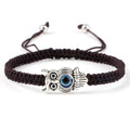 Brown cord bracelet with a silver tone owl centerpiece holding a blue eye