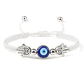 White cord bracelet with a round blue eye and two silver tone Hamsa hands