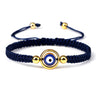 Blue cord bracelet with an open gold tone circular frame surrounding the blue eye