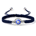 Blue knotted cord bracelet with a blue eye inside an open silver tone circular frame
