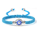 Turquoise cord bracelet with a blue eye inside an open silver tone ring