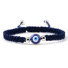 Blue knotted cord bracelet with one round blue eye and silver tone side beads