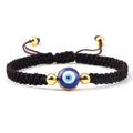 Brown knotted cord bracelet with a round blue eye and gold tone bead details