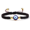 Brown knotted cord bracelet with a round blue eye and gold tone bead details
