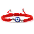Red knotted cord bracelet with a round blue eye and silver tone side beads