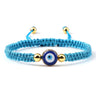 Turquoise knotted cord bracelet with a round blue eye and gold tone side beads